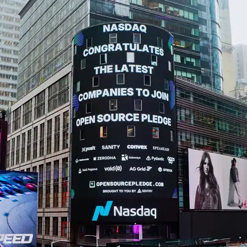 The big Nasdaq screen in Times Square bearing a message saying “Nasdaq celebrates one year of the Open Source Pledge and the companies who pay maintainers”, and many company logos underneath